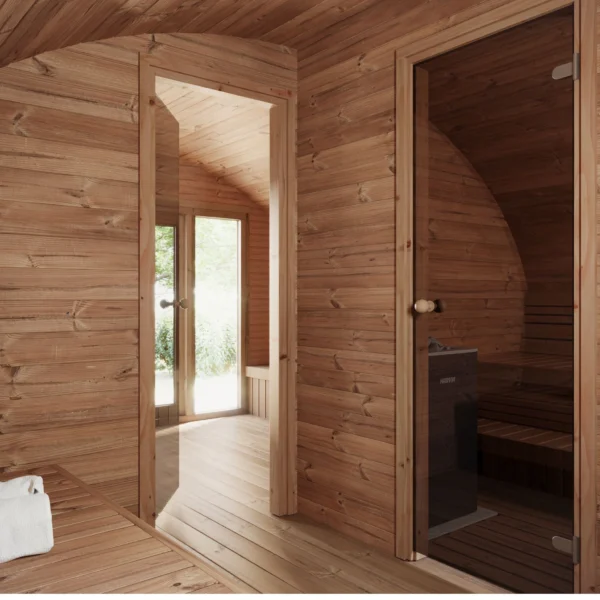 Interior view of the Ilmarinen sauna showing a wooden doorway leading to the steam room, with finely crafted wood paneling and natural light streaming through the glass door.